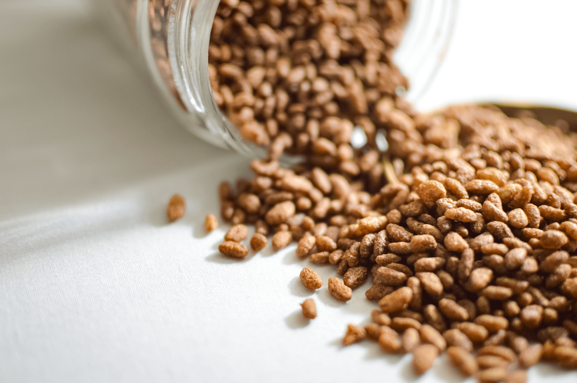 Puffed grains spilling from a glass jar