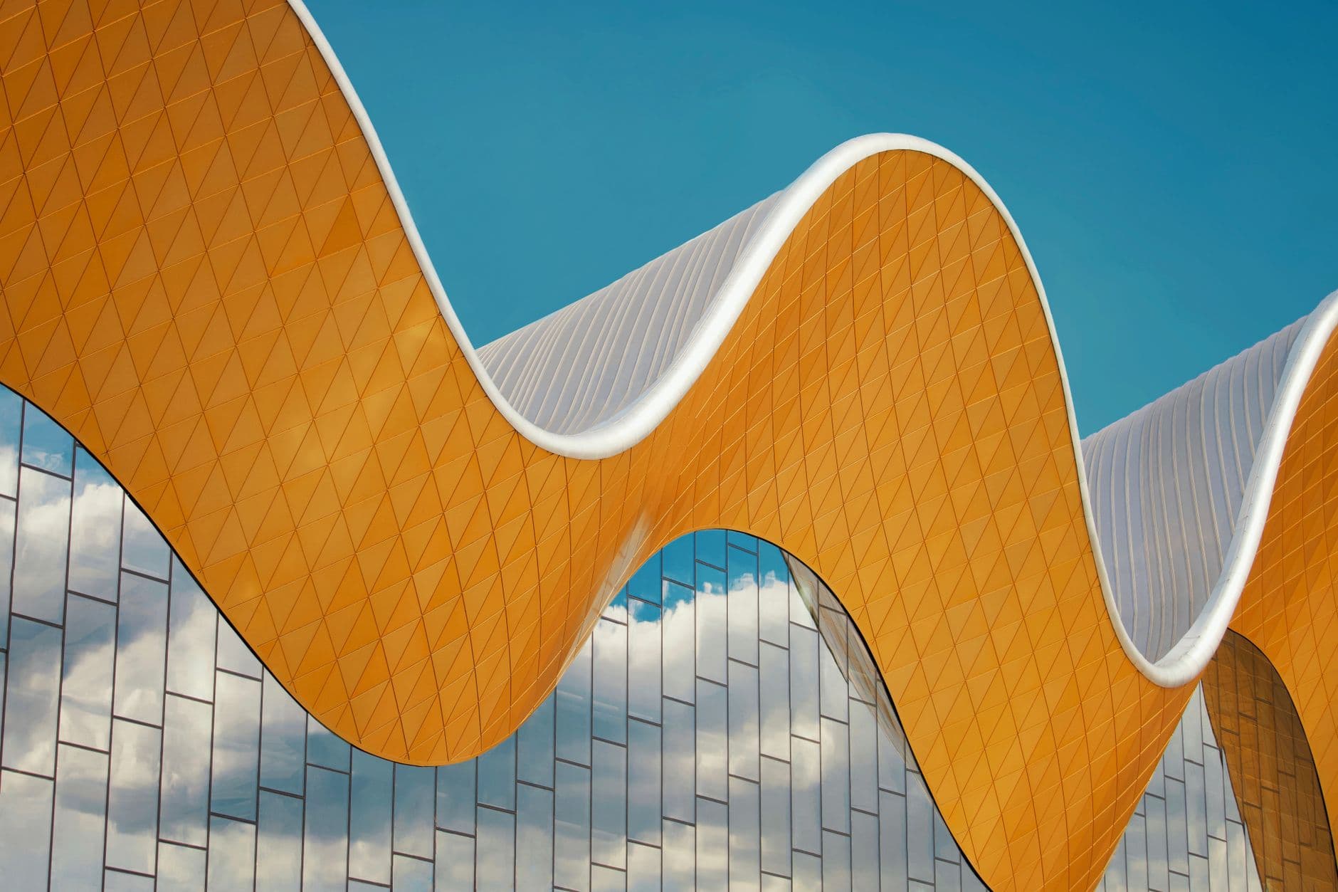 A rippling wave-form facade against a blue sky