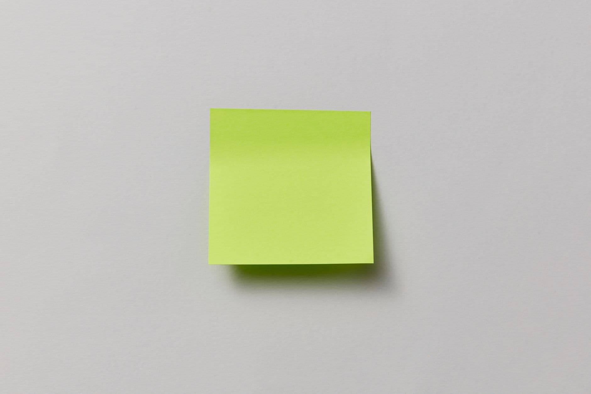 A single blank note on a plain wall
