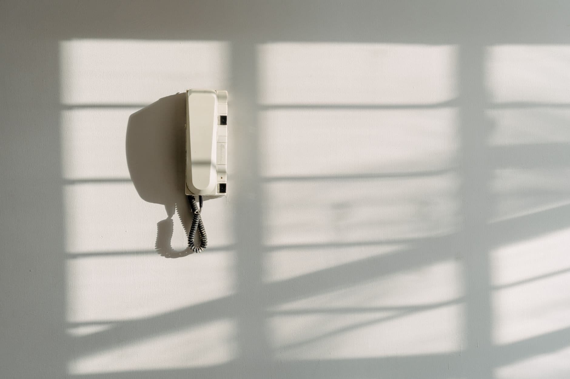 A wall telephone in window light