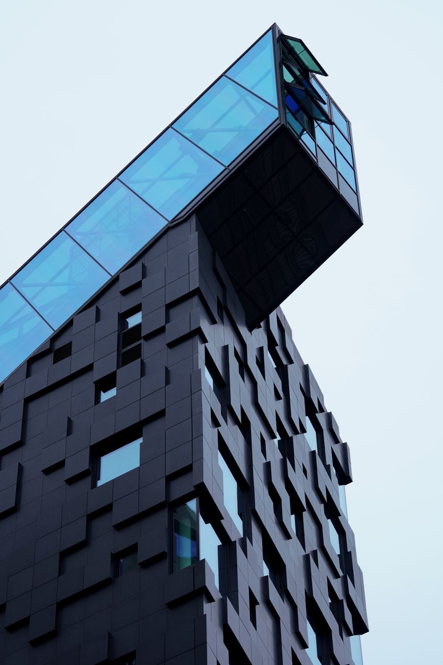 A glass extension cantilevered over a dark facade