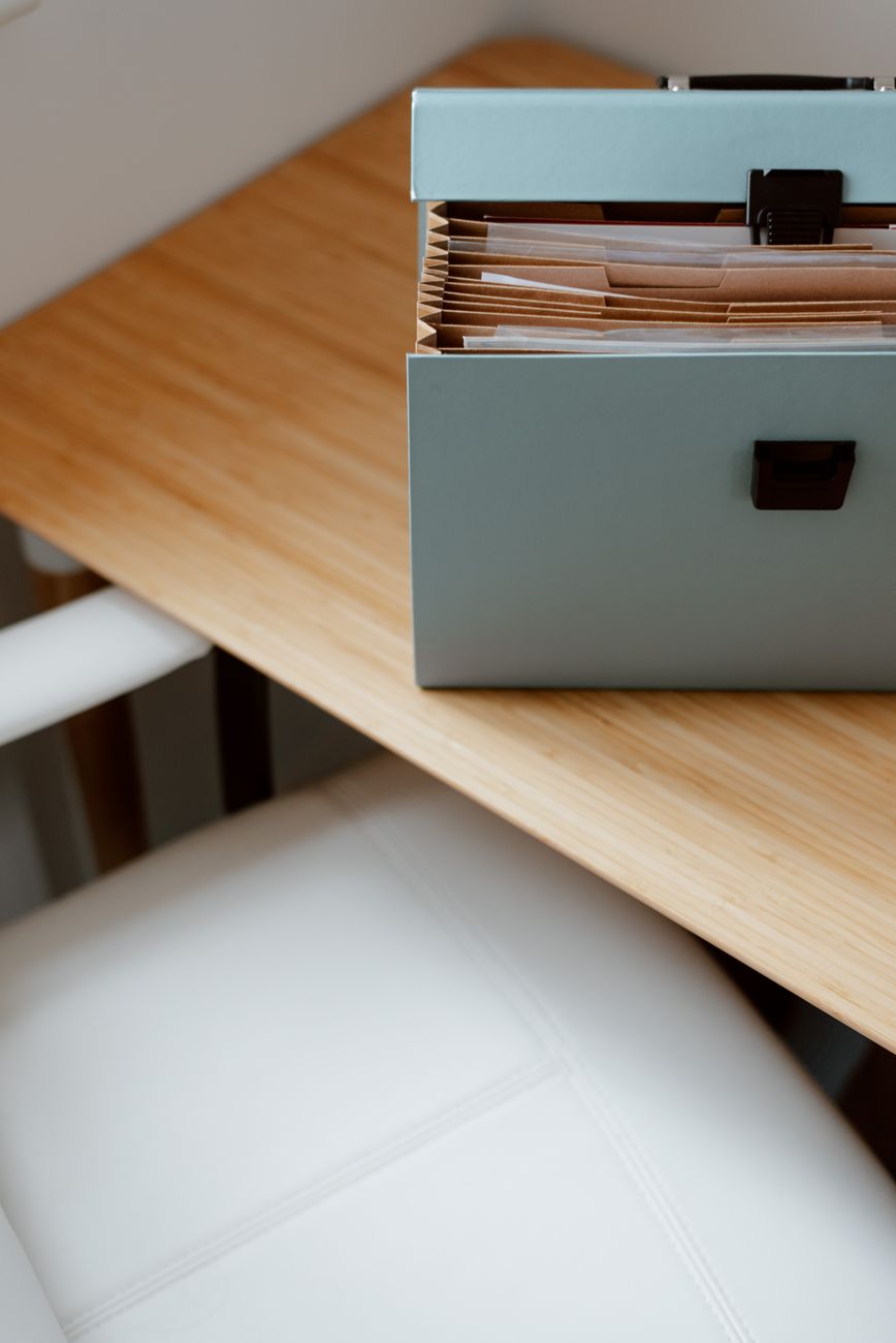An open box of filed paper documents on a desk