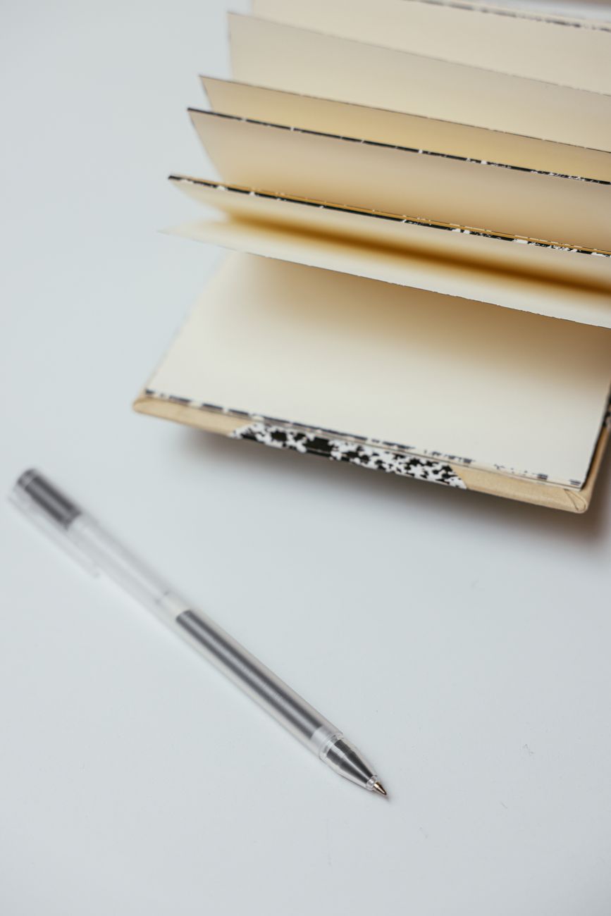 An open blank notebook with a pen beside it