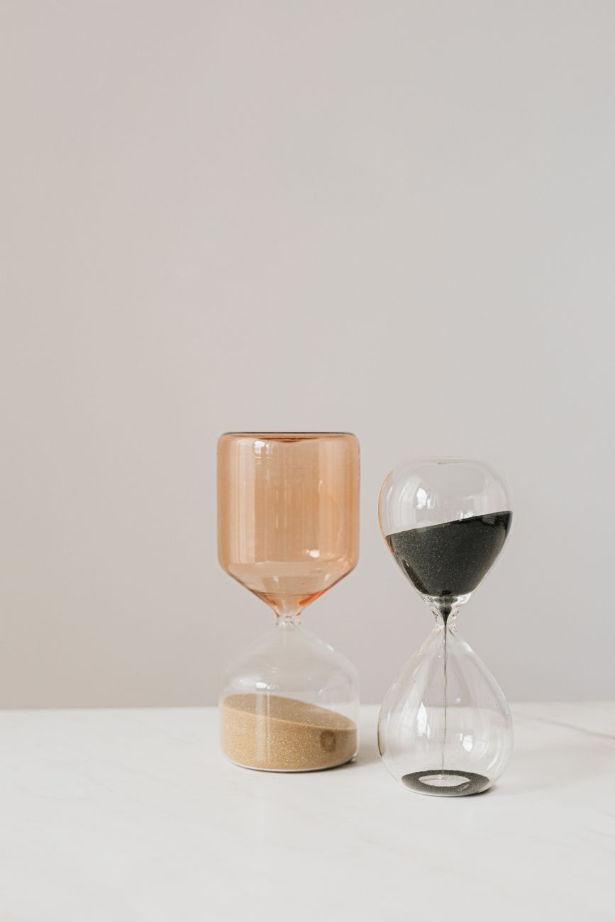 Two hourglasses on a plain table