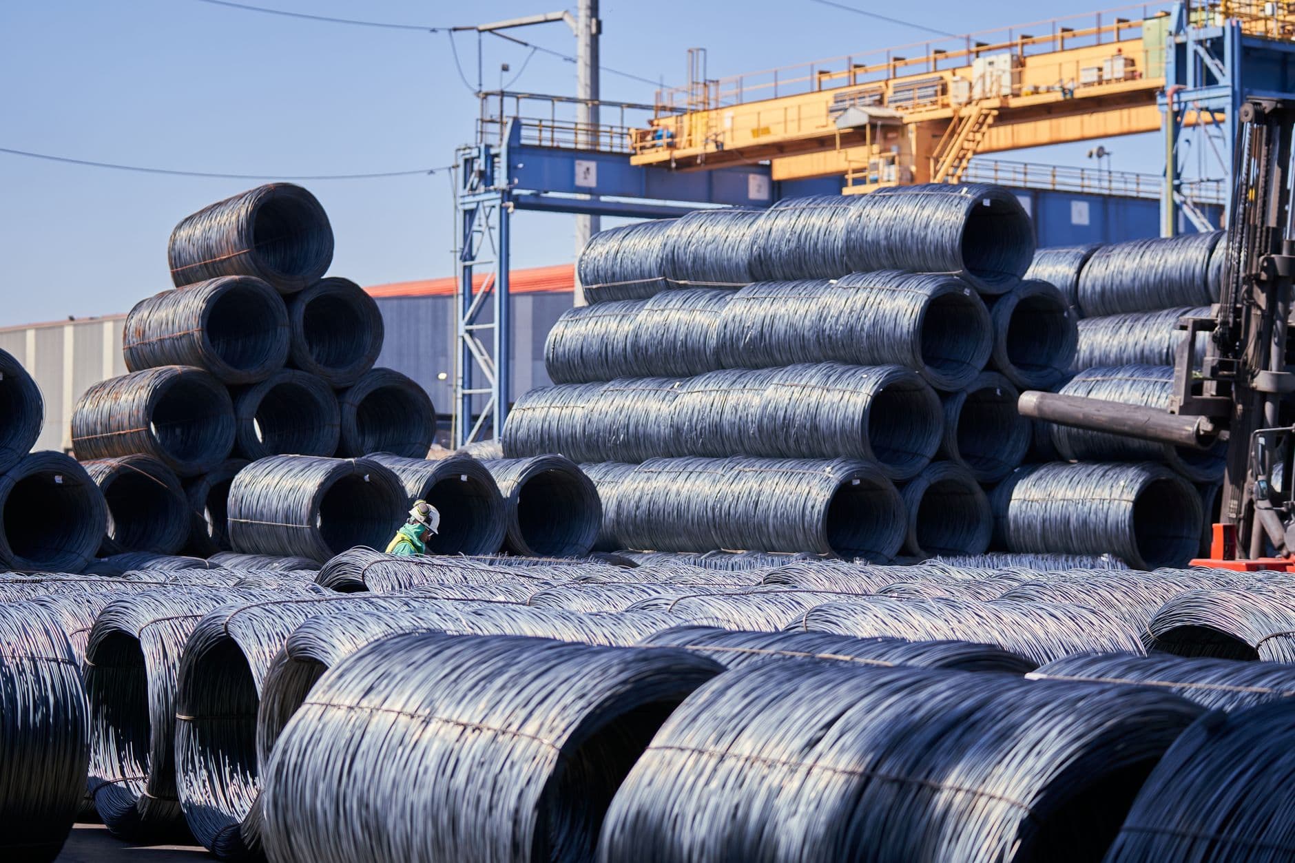 Stacked coils of steel wire in an industrial yard