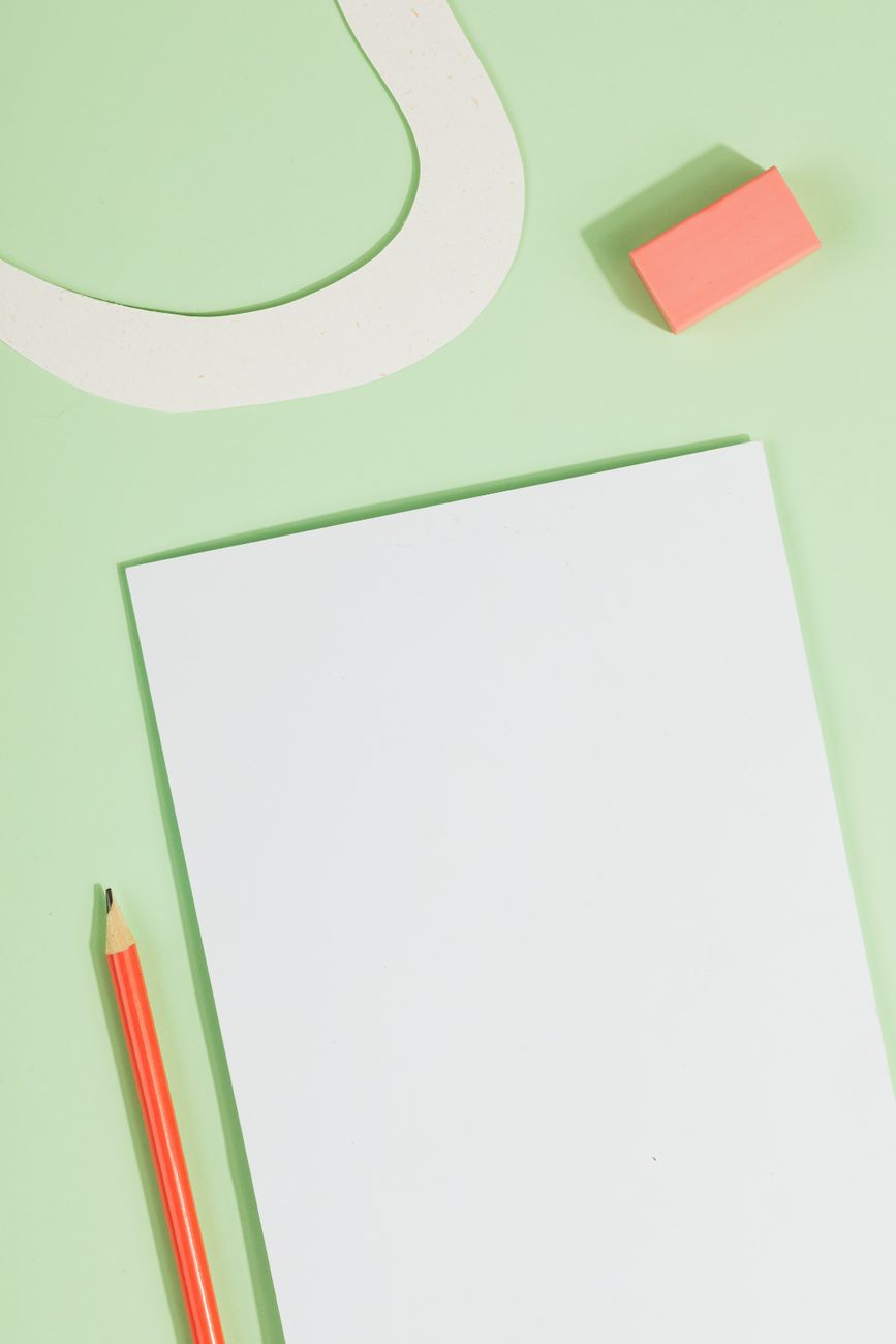 A pencil and eraser beside a blank page
