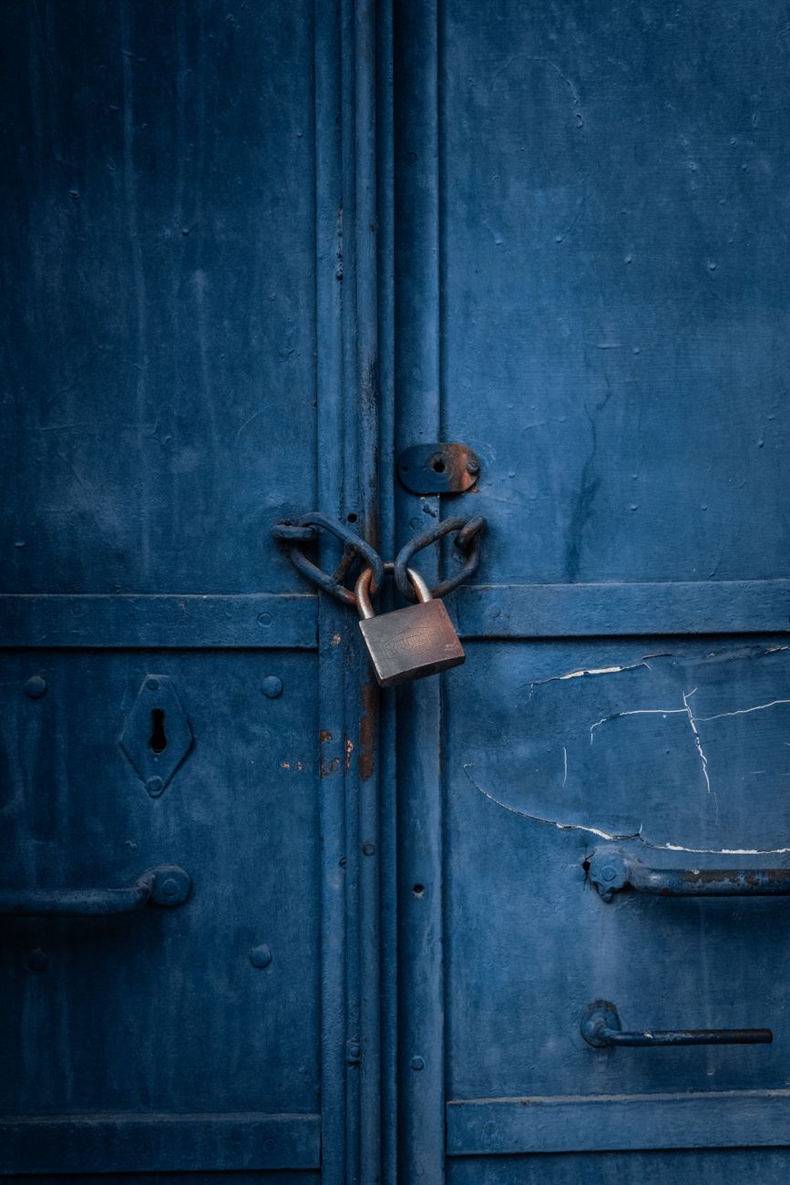A chained padlock on blue metal doors