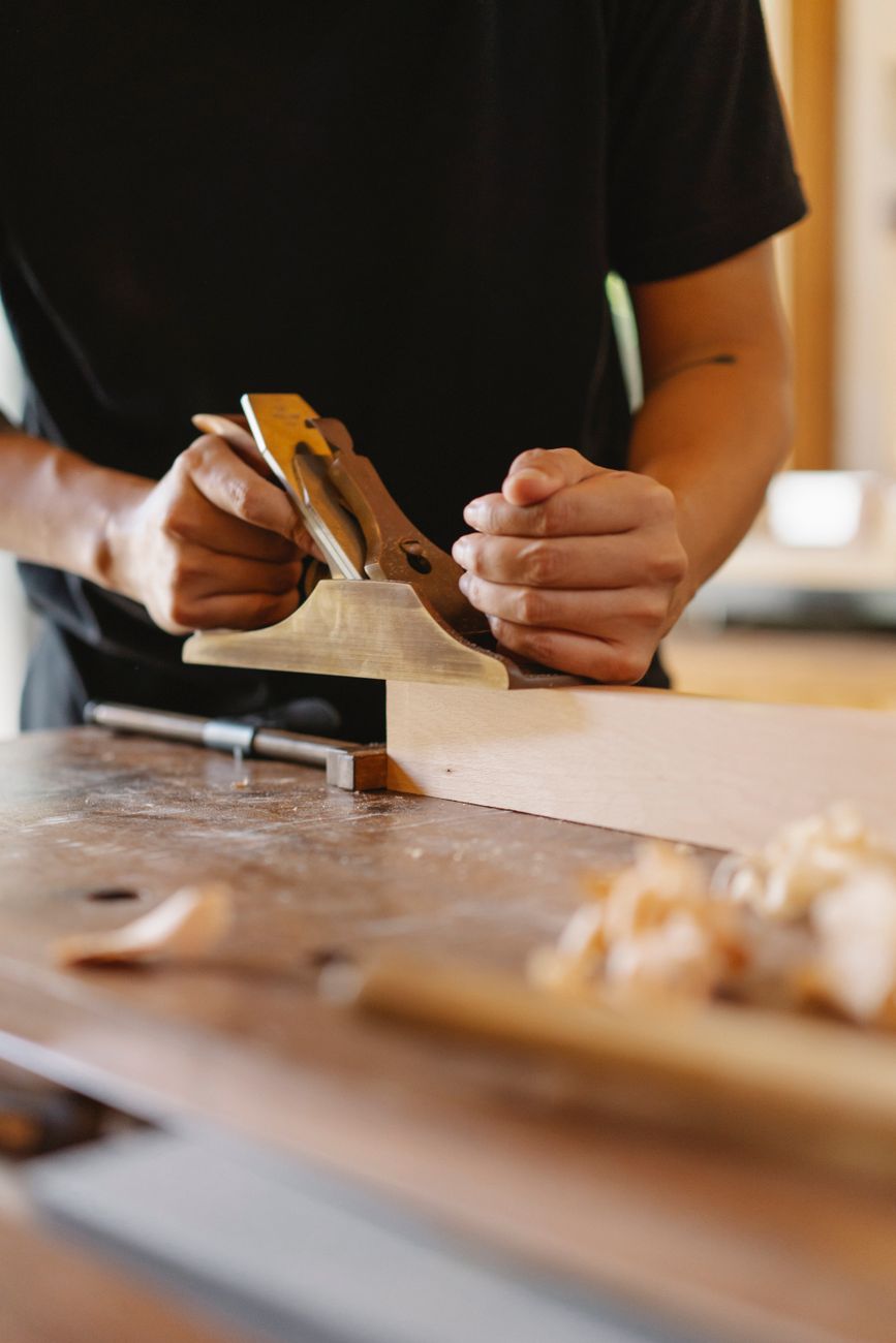 Hands smoothing a board with a bench plane