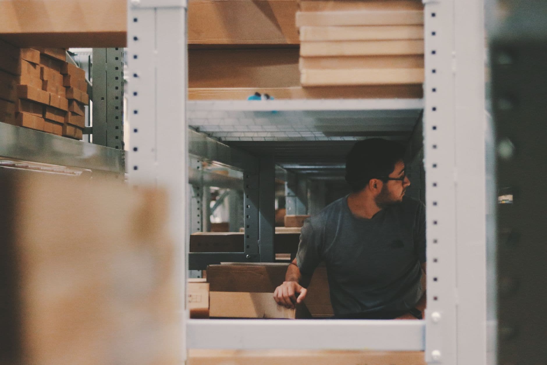 A worker placing cartons into a storage location during put-away